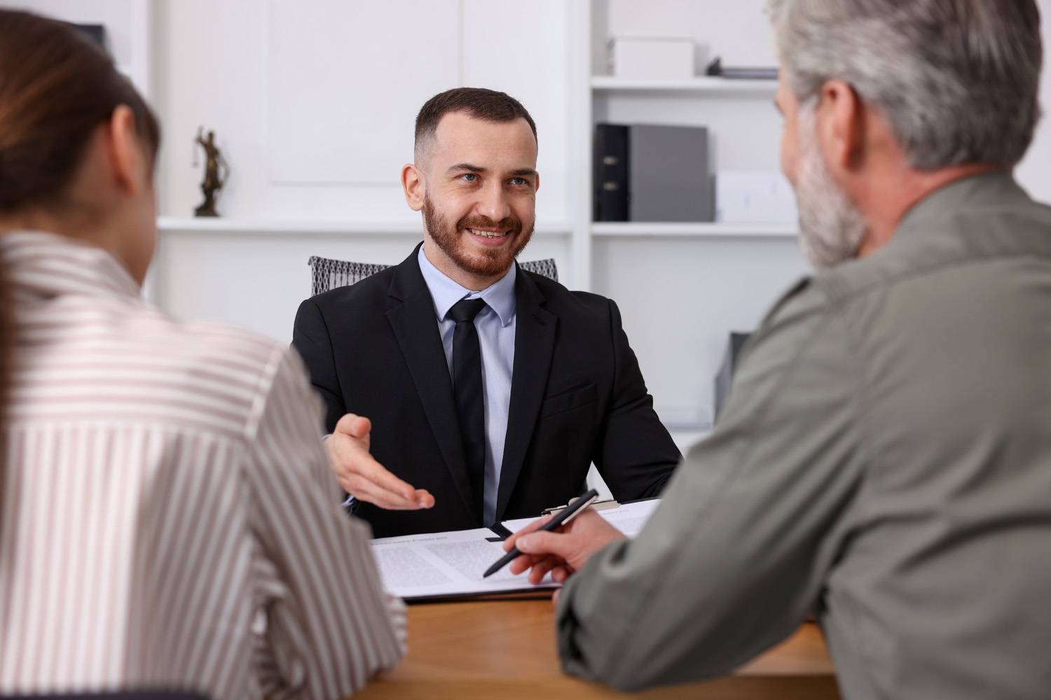 Professionnel libéral recevant deux clients dans son bureau